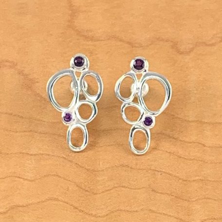 A pair of Marsh Point Earrings with amethyst and purple stones.